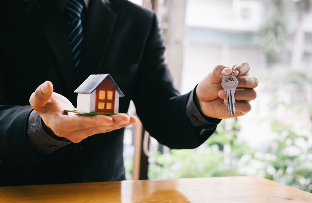 Man with model house and key