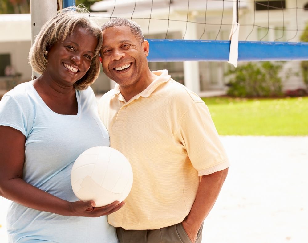 Mn and woman smiling with a beach ball