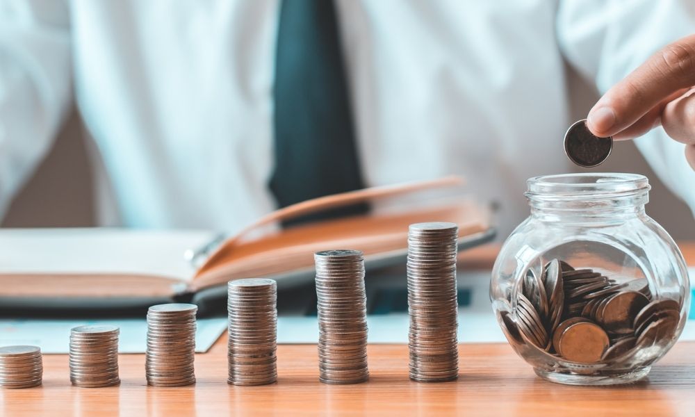 Man putting money in a jar